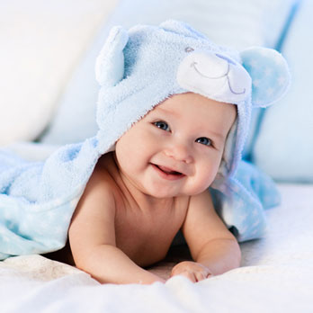 smiling baby wrapped in a blue towel